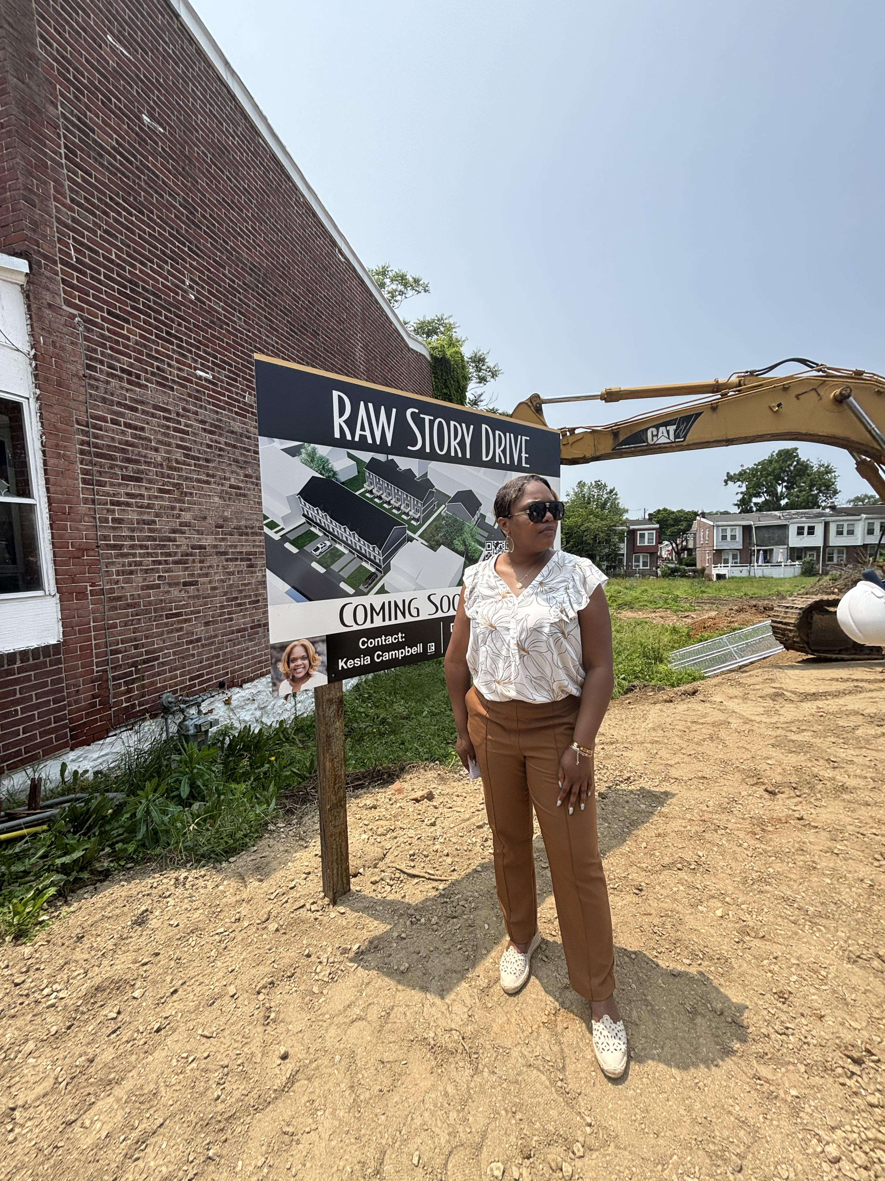 Kesia Campbell posing in front of the Raw Story Drive Construction Sign, off-guard