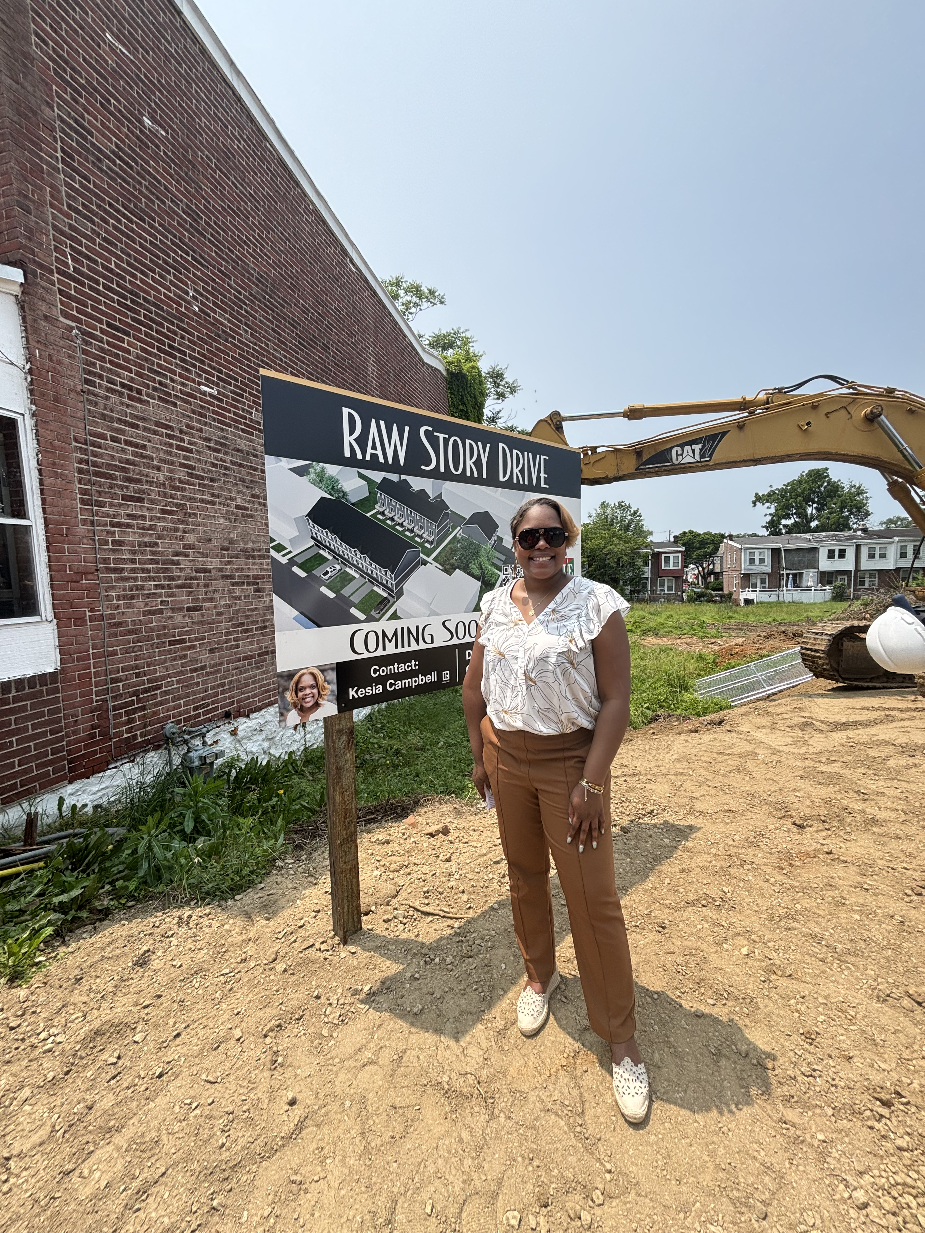 Kesia Campbell posing in front of the Raw Story Drive Construction Sign
